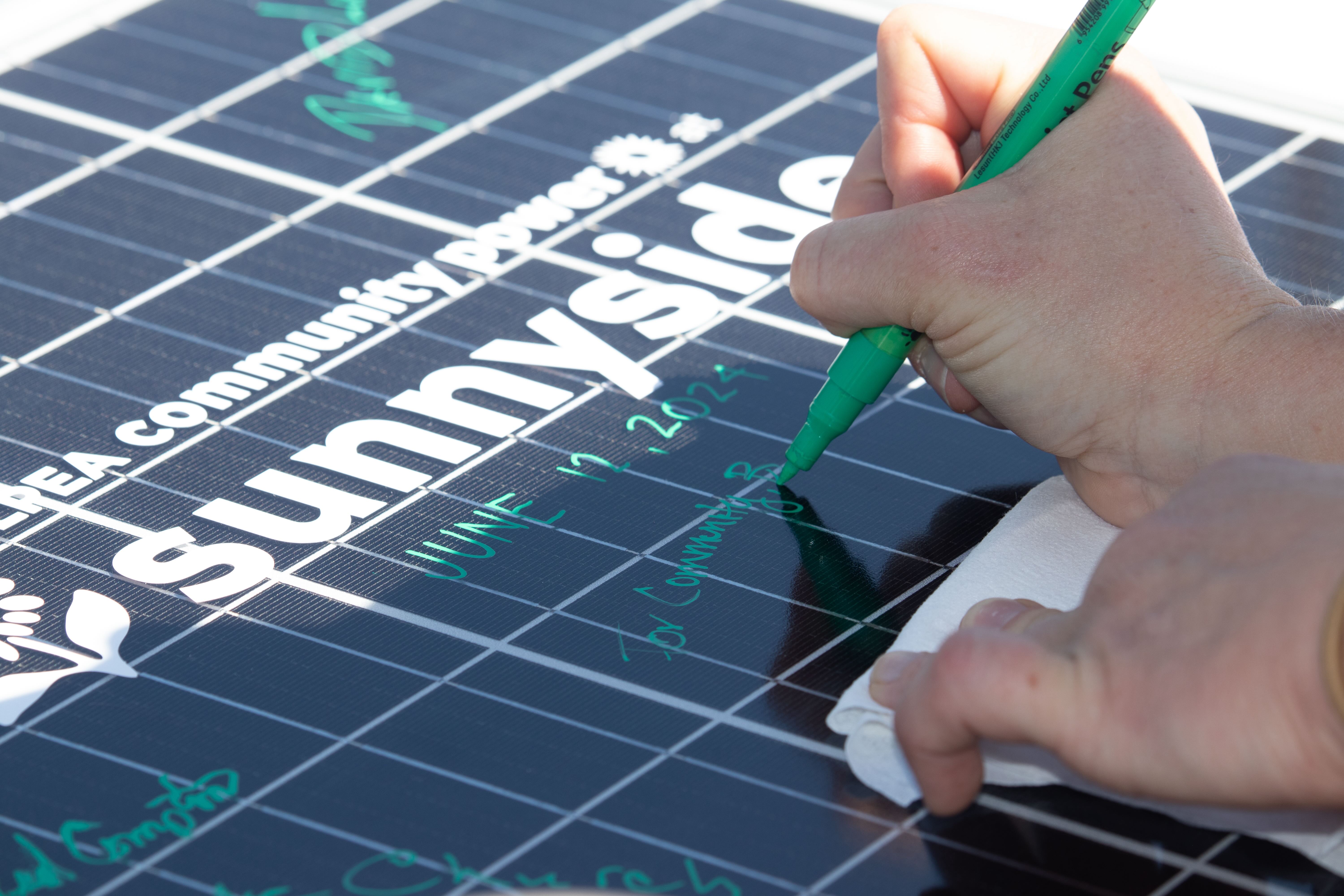 Collaborators signed a community solar panel to commemorate the event