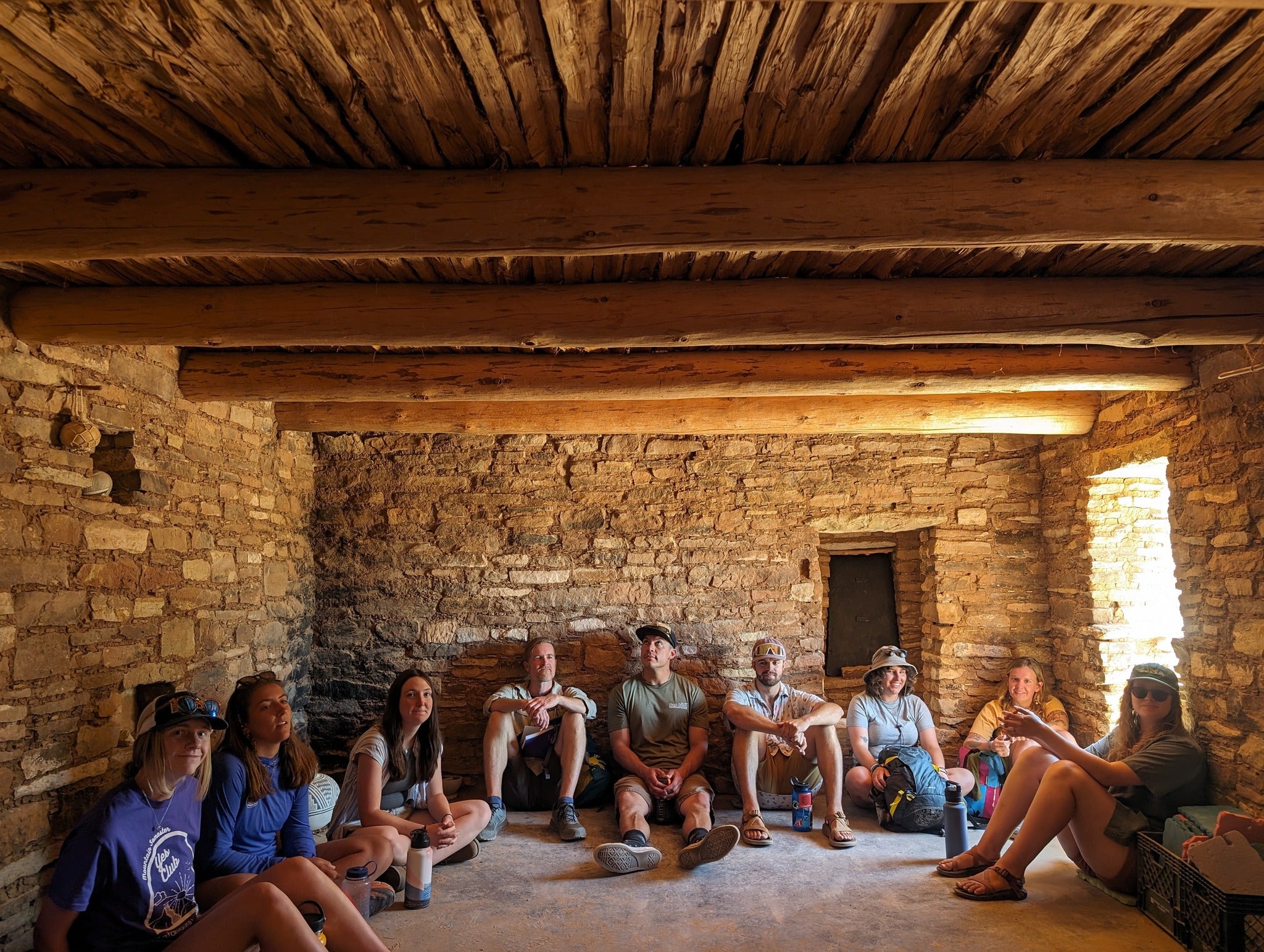 People from the San Juan Mountains Association sitting around an ancient stone structure