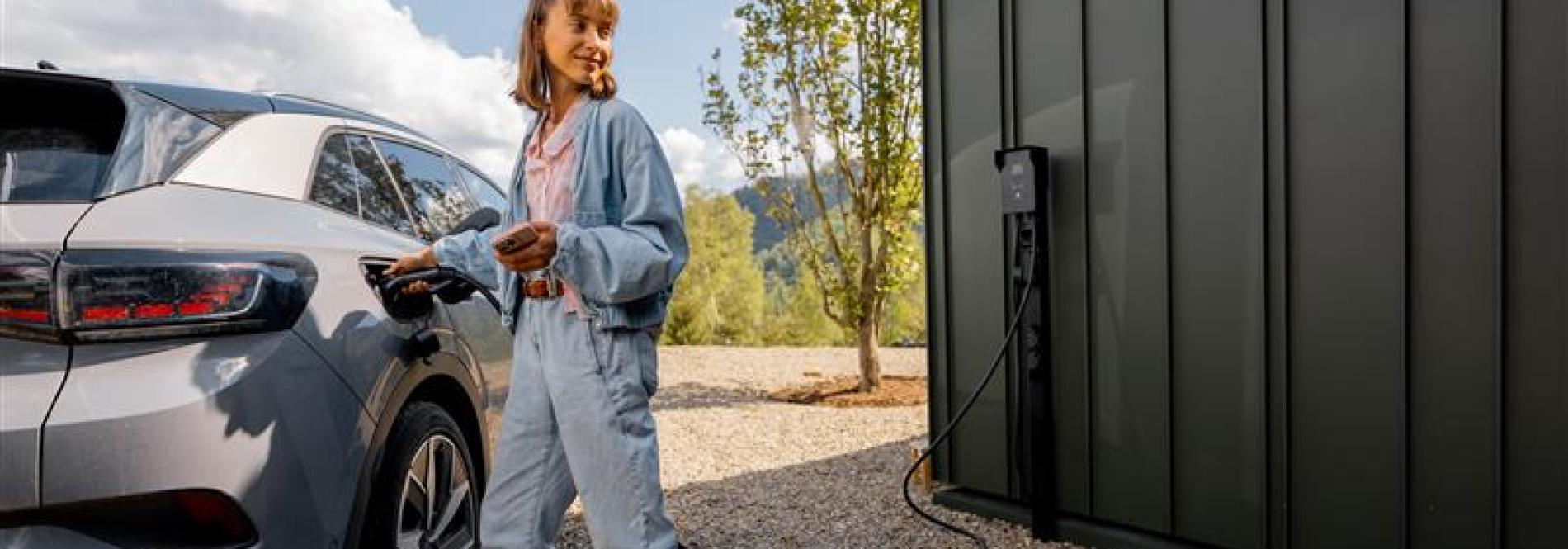 A young woman charging an electric vehicle