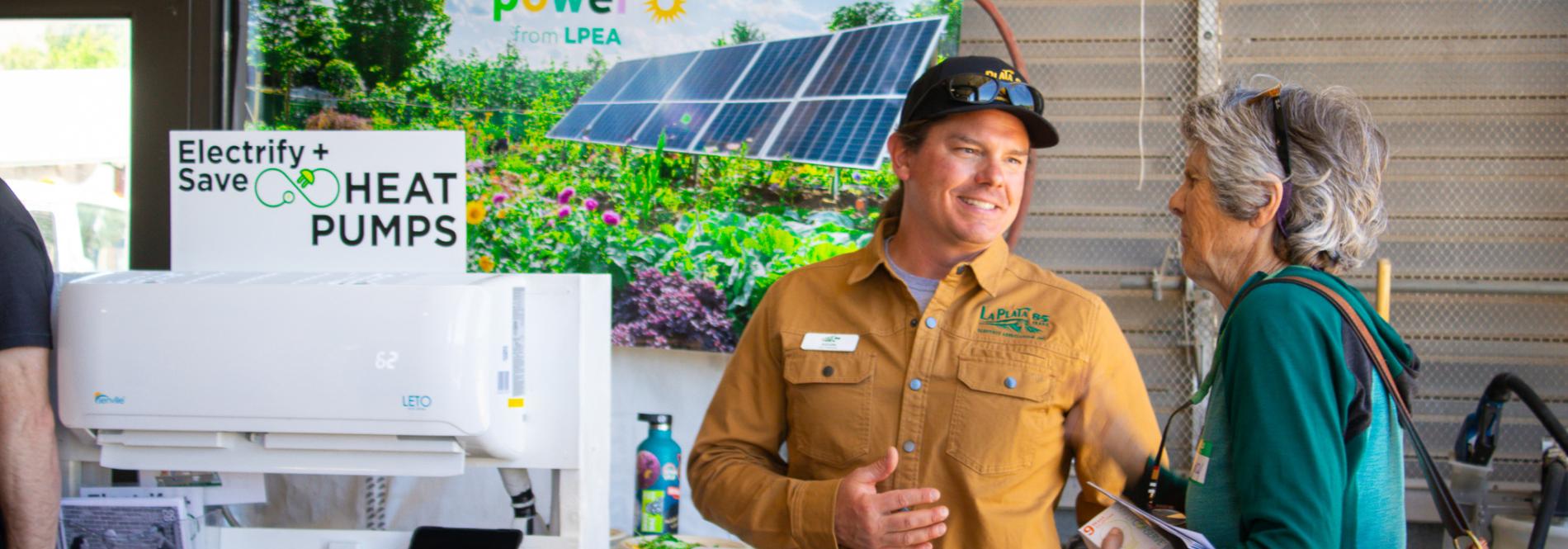 A man and woman talk about heat pumps